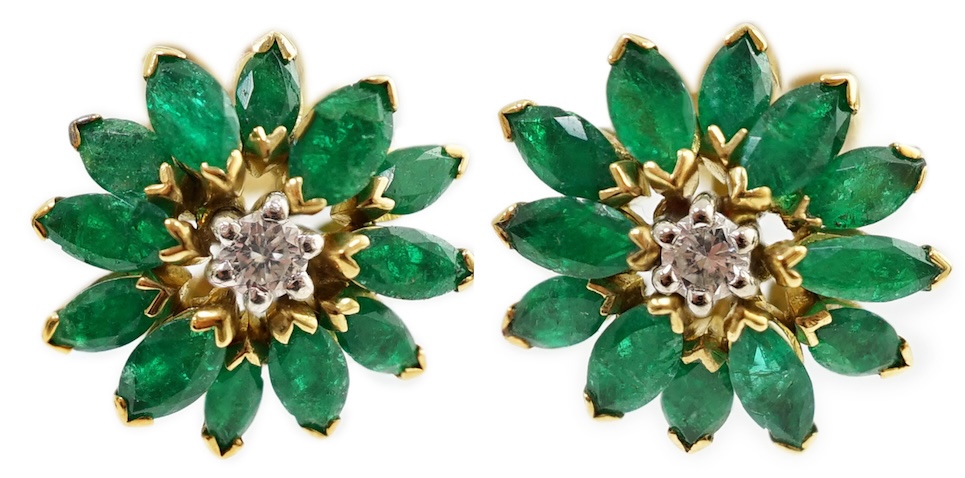 A modern pair of yellow metal, emerald and diamond set flowerhead stud earrings, 13mm, gross weight 6.4 grams. Condition - poor